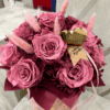Jesienny flower box w kolorze śliwki – welurowe pudełko z bukietem intensywnie pomarańczowych róż, białymi dodatkami i złotym serduszkiem z napisem „rękodzieło”.
