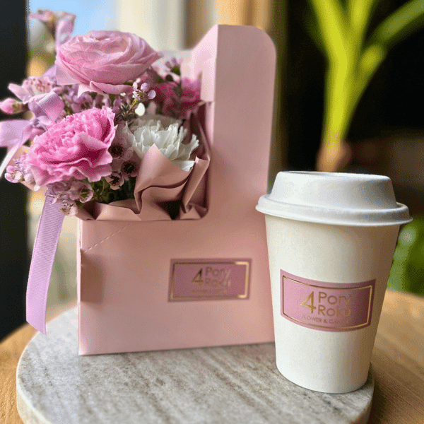 bukiet kwiatów i kawa w pięknym różowym opakowaniu