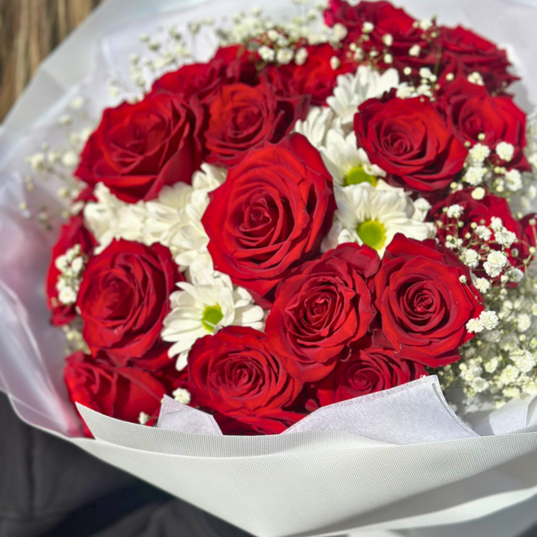 bukiet biało czerwony z czerwonej róży, białej margaretki i białej gipsówki w białym papierze